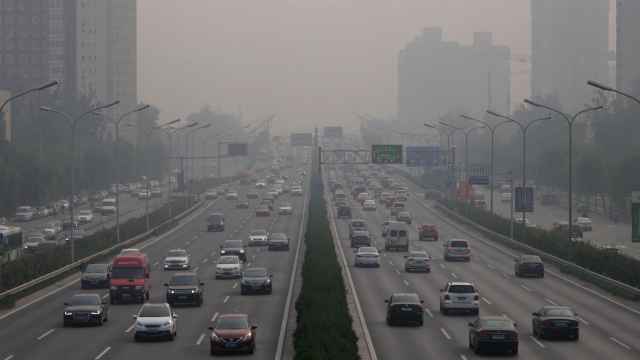 Tráfico en un día con mucha polución en Pekín.