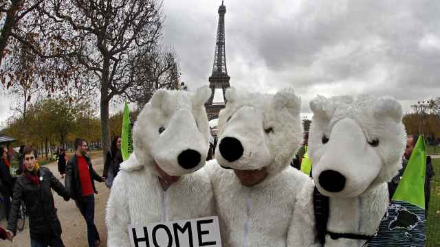 Tres manifestantes disfrazados de osos polares, ayer en París.