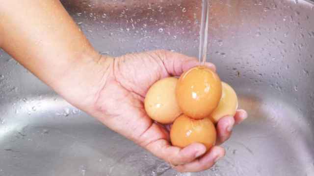 Una persona lava unos huevos.