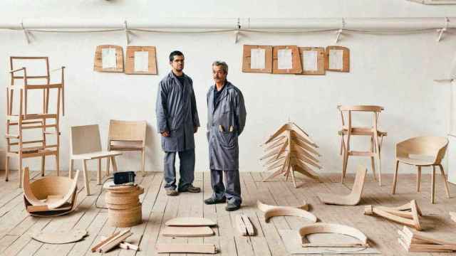 Trabajadores de Andreu World, junto a piezas de madera de sus afamadas sillas. EE